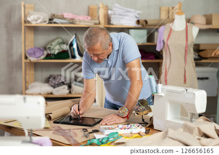 Man tailor makes pattern using tablet 126656165