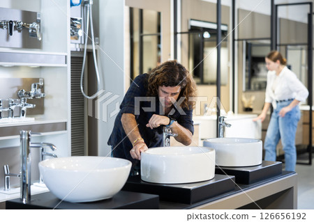 Confident man picking out new bathroom sink in hardware store 126656192