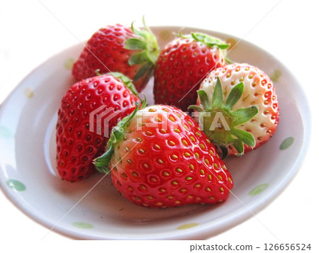 Five strawberries with stems on a white plate 126656524
