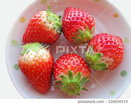 Five strawberries with stems on a white plate Five strawberries with stems on a white plate 126656533