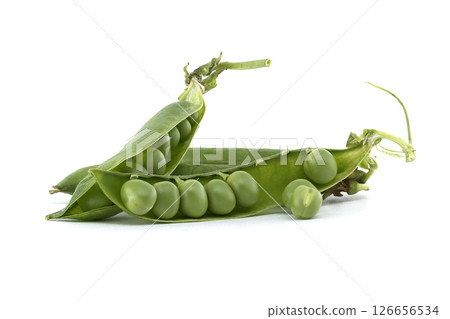 Vibrant green peas spilling from open pods on a crisp white backdrop, ready to be enjoyed. 126656534