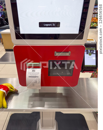 Self-service checkout at a supermarket in Penang with receipt printing and bananas on the counter 126656568
