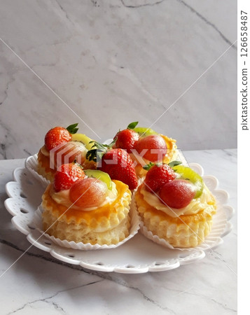 Rich and creamy burnt cheesecake with a perfectly caramelized top, crowned with fresh fruits for a delightful burst of flavor and texture in every bite. 126658487