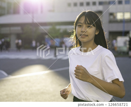 夕陽下奔跑的微笑女跑者 126658721