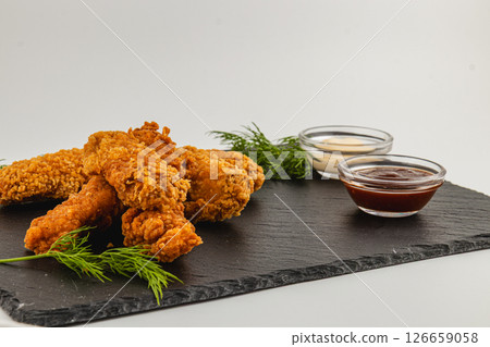 Crispy fried chicken served with dipping sauces on slate board Crispy fried chicken served with dipping sauces on slate board 126659058