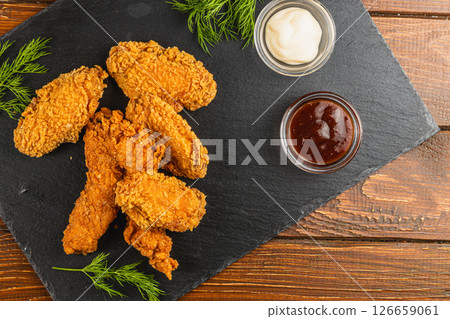 Crispy fried chicken wings served with dipping sauces 126659061