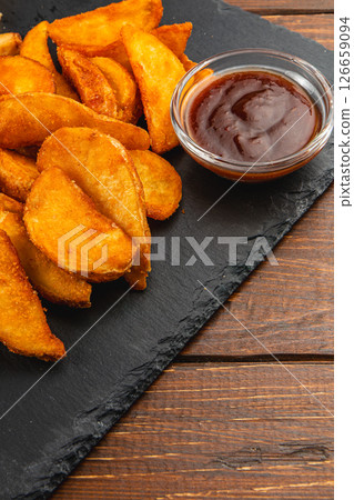 Golden crispy potato wedges served with dipping sauce 126659094