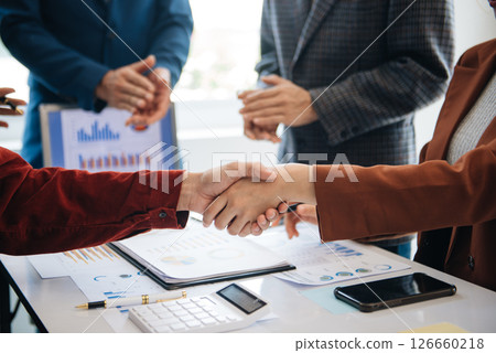 business people shaking hands during a meeting in modern office business people shaking hands during a meeting in modern office 126660218