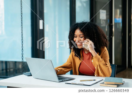 Young woman typing on tablet and laptop while sitting at the working in office 126660349