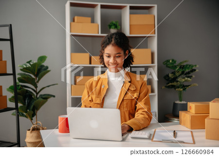 Young African woman prepare parcel box and standing check online orders for deliver to customer on tablet, laptop Shopping Online concept. 126660984