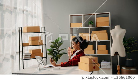 Young African woman running online store Startup small business SME, using smartphone or tablet taking receive and checking online purchase shopping order 126661000