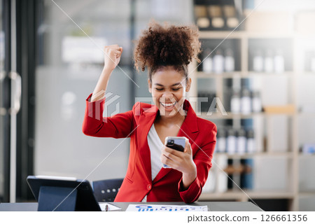 Asian business woman are delighted and happy with the work they do on their tablet, laptop and taking notes at the office. 126661356