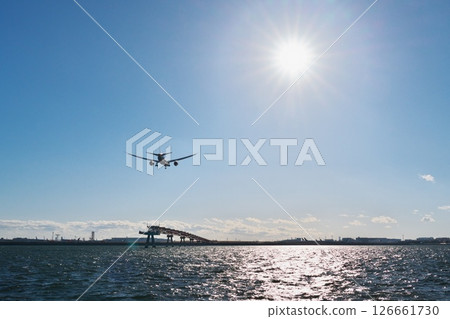 On a clear winter day, the sun welcomes a passenger plane heading for runway B at Haneda Airport, as seen from Jonanjima Seaside Park. On a clear winter day, the sun welcomes a passenger plane heading for runway B at Haneda Airport, as seen from Jonanjima Seaside Park. 126661730