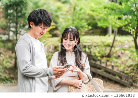 Young Asian couple visiting a tourist spot and searching information on their smartphone (apps, travel, tourism, gourmet) Young Asian couple visiting a tourist spot and searching information on their smartphone (apps, travel, tourism, gourmet) 126661938