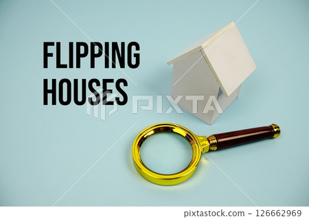 Flipping Houses text with White Model House and magnifying glass on blue background Flipping Houses text with White Model House and magnifying glass on blue background 126662969