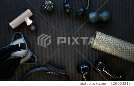 Black exercise mat, dumbbells, headphones, massager, gloves and other sports equipment 126663211