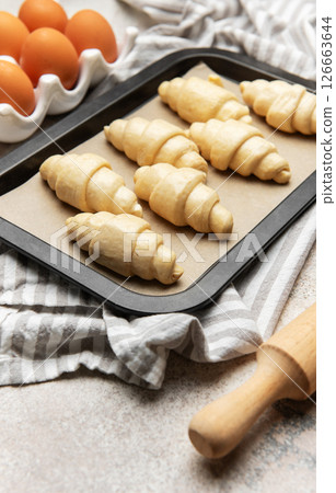 Freshly made croissants resting on baking sheet await oven's warm embrace 126663644