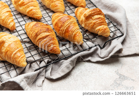 Freshly baked croissants cooling on wire rack, perfect start to the day 126663651