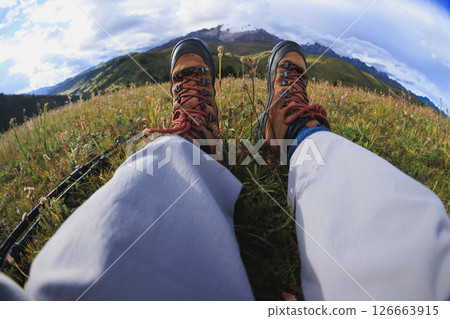 Woman hiking on high altitude mountains top,sit on the grass 126663915