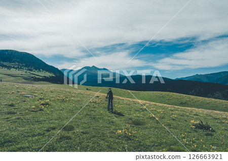 Woman riding mountain bike on beautiful flowering grassland mountain top 126663921