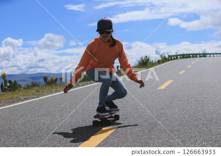 Skateboarder skateboarding on the mountain road 126663933