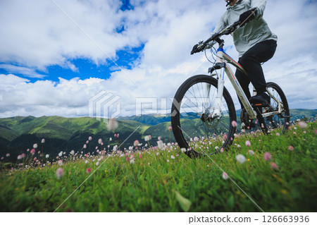 Asian woman riding mountain bike on beautiful mountain top Asian woman riding mountain bike on beautiful mountain top 126663936