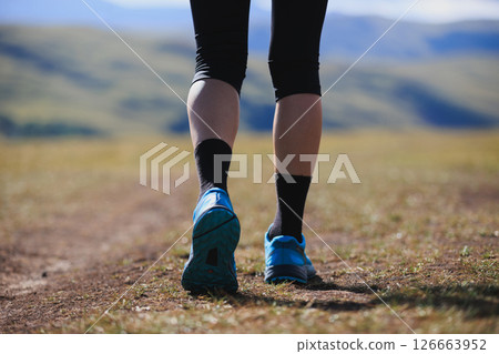Fitness woman runner running at high altitude grassland mountain top road Fitness woman runner running at high altitude grassland mountain top road 126663952