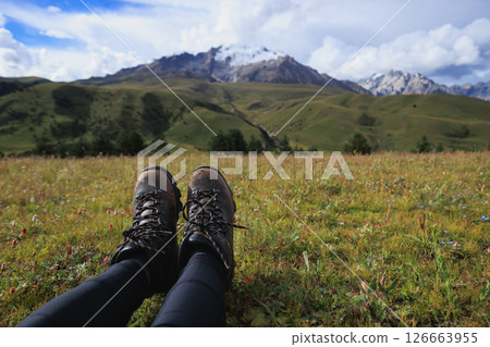 Woman hiking on high altitude mountains top,sit on the grass Woman hiking on high altitude mountains top,sit on the grass 126663955