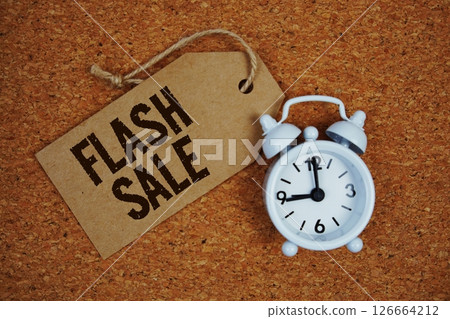 Flash Sale text on price tag with alarm clock on cork board background 126664212