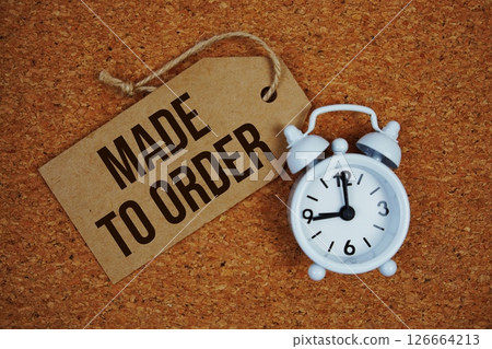 Made to Order text on price tag with alarm clock on cork board background 126664213