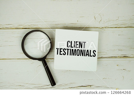 Client Testimonials text message on sticky note with magnifying glass on wooden background Client Testimonials text message on sticky note with magnifying glass on wooden background 126664268