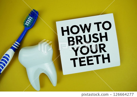 How to Brush Your Teeth with alarm clock dental hygiene concept top view on yellow background 126664277