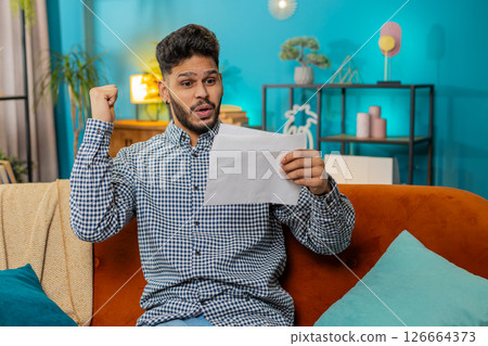 Man open envelope letter reads it feel happy, career growth advance promotion, bank loan approve Man open envelope letter reads it feel happy, career growth advance promotion, bank loan approve 126664373