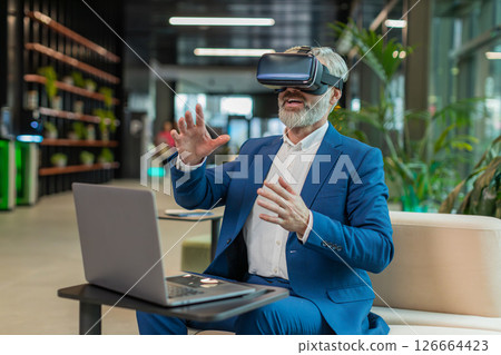 Mature businessman software developer using headset app making presentation in modern office lobby 126664423