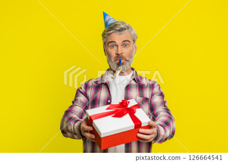 Mature man handing presenting birthday gift box cone hat blower joyful expression festive atmosphere 126664541