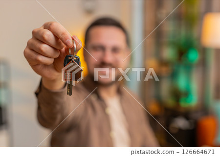 Happy businessman real estate agent using laptop at home office desk showing the keys of new house Happy businessman real estate agent using laptop at home office desk showing the keys of new house 126664671