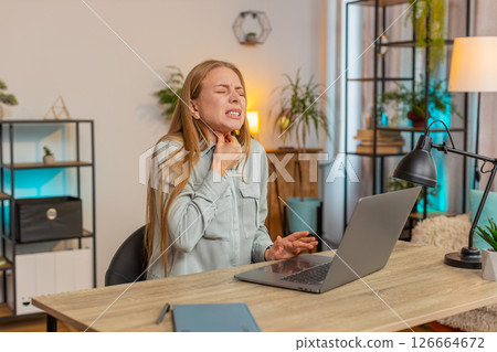 Upset mature Caucasian woman freelancer having sore throat while sitting at home office table desk Upset mature Caucasian woman freelancer having sore throat while sitting at home office table desk 126664672