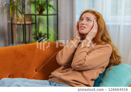 Sick ill woman on sofa rubbing temples to cure headache problem, suffering from tension and migraine 126664916