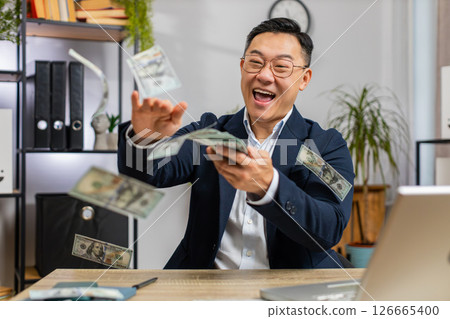 Happy rich successful businessman throwing sharing money dollar cash big profit winning at office 126665400