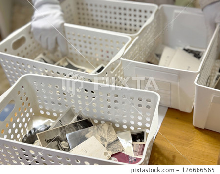 一個裝滿黑白照片的盒子和一隻戴著白手套的手 126666565