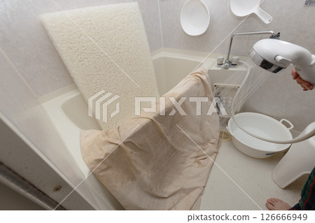 Washing the mattress and duvet cover in the shower in the bathroom 126666949