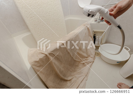 Washing the mattress and duvet cover in the shower in the bathroom 126666951