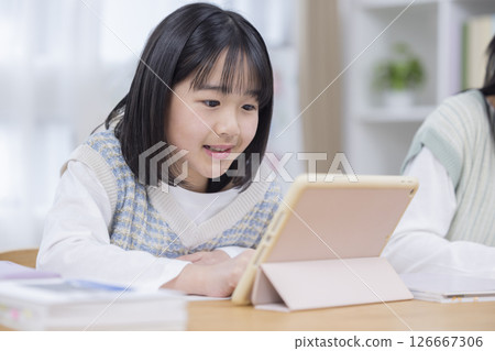 Girl studying on a tablet Girl studying on a tablet 126667306