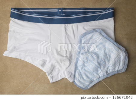 Male incontinence pads on white panties. Incontinence pads for men. Urinary incontinence. Sanitary pads for men with problems of the genitourinary system. Male incontinence pads on white panties. Incontinence pads for men. Urinary incontinence. Sanitary pads for men with problems of the genitourinary system. 126671043