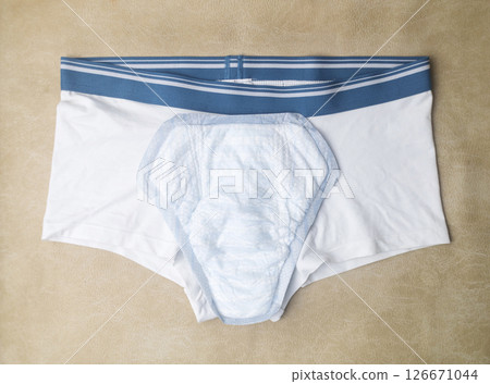 Male incontinence pads on white panties. Incontinence pads for men. Urinary incontinence. Sanitary pads for men with problems of the genitourinary system.  126671044