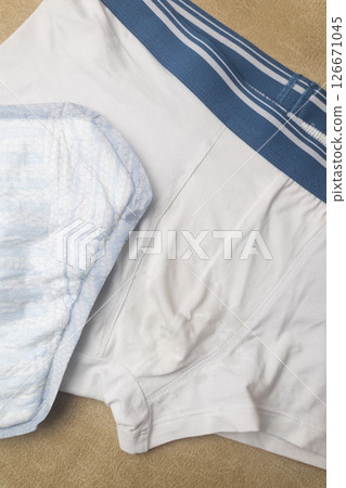 Male incontinence pads on white panties. Incontinence pads for men. Urinary incontinence. Sanitary pads for men with problems of the genitourinary system.  126671045