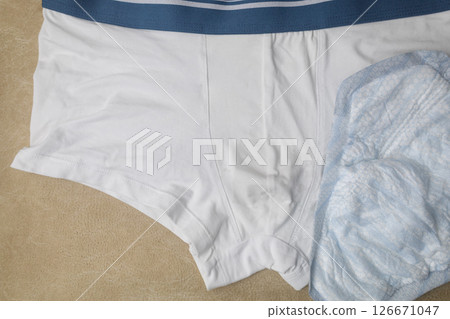 Male incontinence pads on white panties. Incontinence pads for men. Urinary incontinence. Sanitary pads for men with problems of the genitourinary system.  126671047