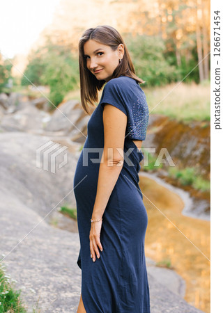 Pregnant Woman In Blue Dress By The Nature Stream 126671454
