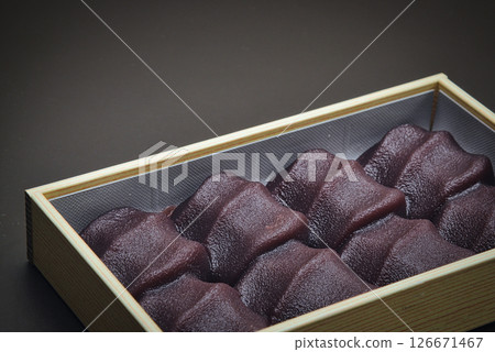 享用這款美味的日本糖果，它由柔軟的麻糬包裹在光滑的豆沙中，並配上一些日本茶。 126671467