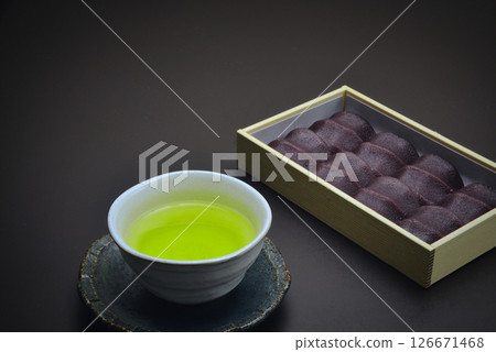 享用這款美味的日本糖果，它由柔軟的麻糬包裹在光滑的豆沙中，並配上一些日本茶。 126671468
